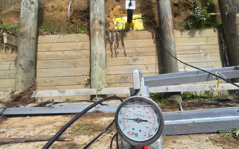 Calibrated gauge being used for proof-load testing of a ground anchor