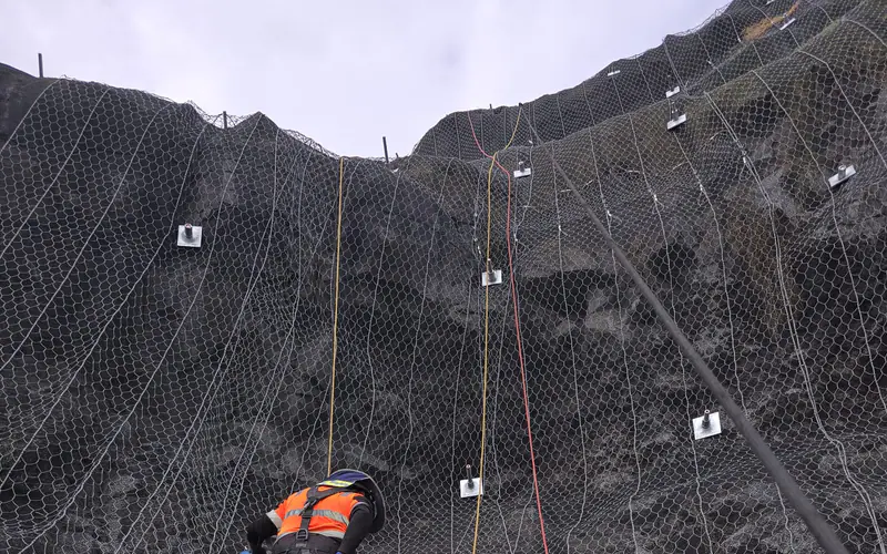 Rock bolts and mesh securing a fractured rock face